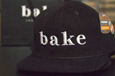 the bake Corduroy black snapback with white logo