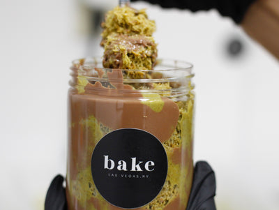 a jar and a spoonfull of Dubai chocolate in a Jar with bake Las Vegas logo