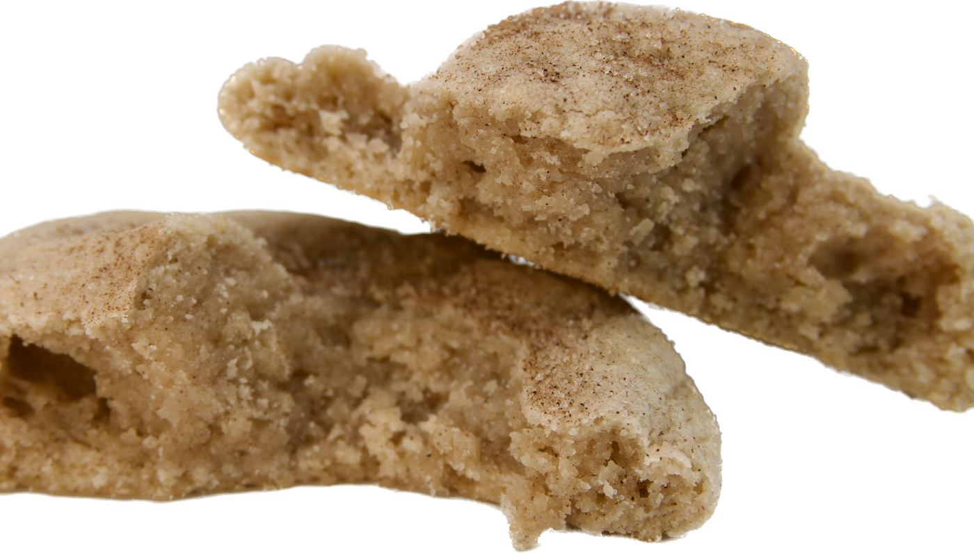A split snickerdoodle cookie showing the soft and chewy interior with a generous dusting of cinnamon sugar on top