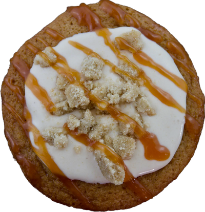 A close-up of a freshly baked guava crumble cookie topped with creamy cream cheese frosting